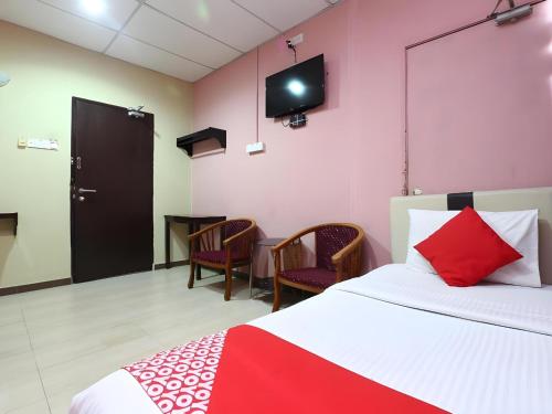 a bedroom with a bed and a tv on the wall at Hotel O Destiny Riverside Hotel in Kota Bharu