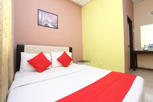 a bedroom with a large bed with red pillows at Hotel O Destiny Riverside Hotel in Kota Bharu