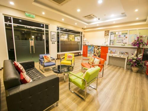 a waiting room with couches and chairs in a store at Capital O 89344 Labuan Avenue Hotel in Labuan