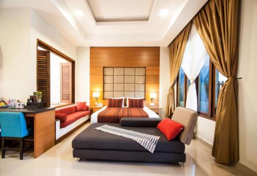 a bedroom with a bed and a couch and a desk at Sunday Telaga Terrace Boutique Resort in Pantai Cenang