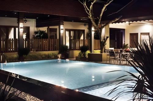 a large swimming pool in front of a house at Sunday Telaga Terrace Boutique Resort in Pantai Cenang
