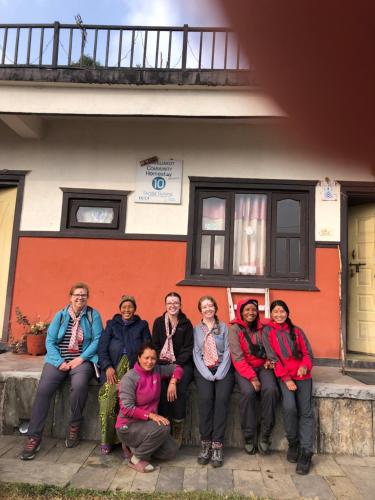 a group of people sitting in front of a house at Anne Homestay in Pokhara