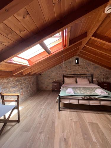 a attic bedroom with a bed and a wooden floor at Koukouri Suites in Areopolis