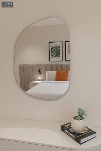 a bedroom with a bed and a mirror at Prime Residence Zayed Heights in Sheikh Zayed