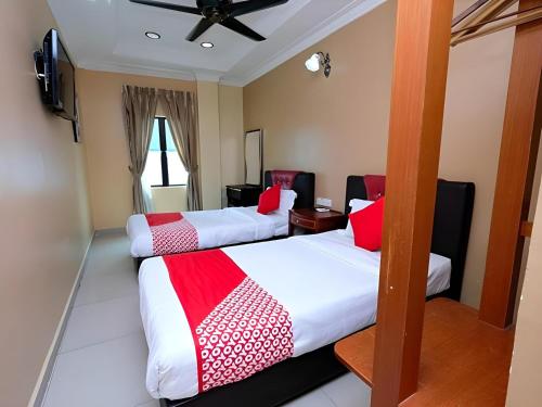 a hotel room with three beds and a flat screen tv at Hotel O Ayuni Hotel in Bangi