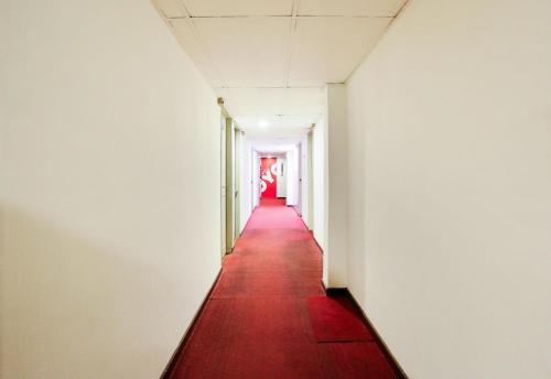 a corridor in an empty room with a red carpet at Hotel O My Hotel in Segamat