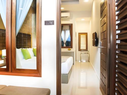a bedroom with a bed and a mirror at Sunday Telaga Terrace Boutique Resort in Pantai Cenang