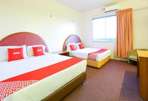 a hotel room with two beds and a window at Hotel O My Hotel in Segamat