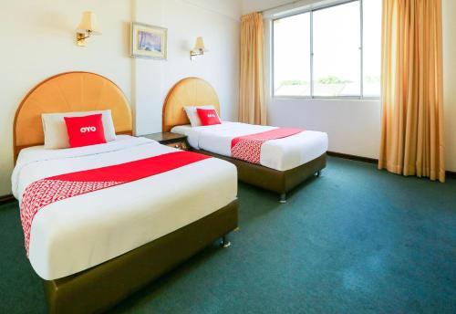 a hotel room with two beds and a window at Hotel O My Hotel in Segamat