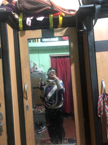 a woman taking a picture of herself in a mirror at Anne Homestay in Pokhara
