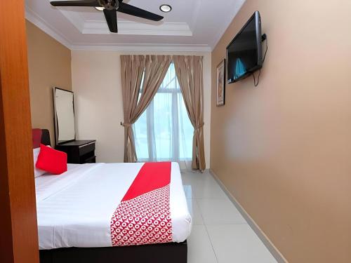 a bedroom with a bed and a flat screen tv at Hotel O Ayuni Hotel in Bangi