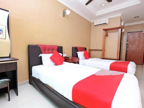 a hotel room with two beds and a television at Hotel O Ayuni Hotel in Bangi