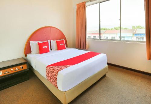 a bedroom with a large bed with red pillows at Hotel O My Hotel in Segamat