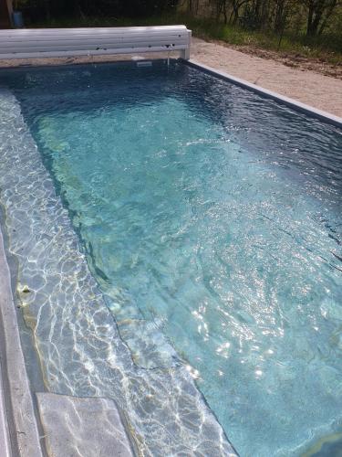une piscine d'eau bleu clair dans une arrière-cour dans l'établissement Chambre dans Petit havre de paix avec piscine chauffée au coeur du Luberon, à Gargas