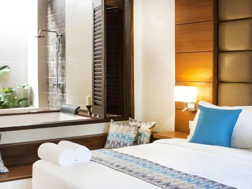 a hotel room with a bed and a bathtub at Sunday Telaga Terrace Boutique Resort in Pantai Cenang