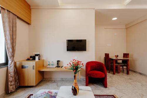 a living room with a vase of flowers on a table at Daksh The Grand Goverdhan in Dwarka