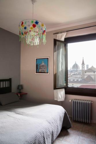 a bedroom with a bed and a window and a chandelier at Hotel Panorama in Florence