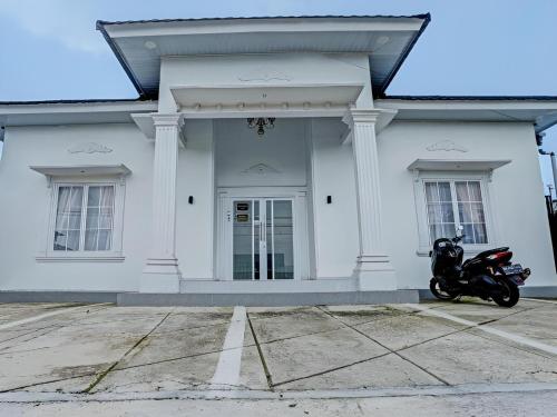 a motorcycle parked in front of a white house at Hotel O Asia City in Kota Kinabalu
