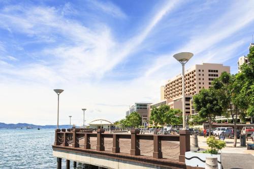 a pier next to a body of water with buildings at Hotel O Asia City in Kota Kinabalu