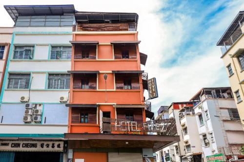 a tall orange building with a balcony at Hotel O Five 2 in Kota Kinabalu