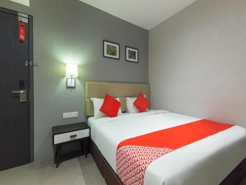 a bedroom with a large bed with red pillows at Yootel Boutique Hotel in Kajang