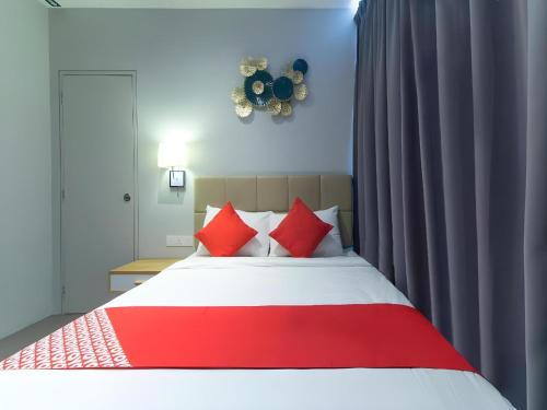 a bedroom with a red and white bed with red pillows at Yootel Boutique Hotel in Kajang