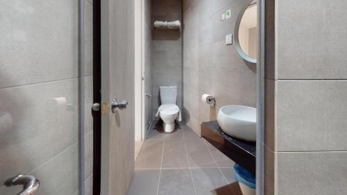 a small bathroom with a toilet and a sink at Yootel Boutique Hotel in Kajang