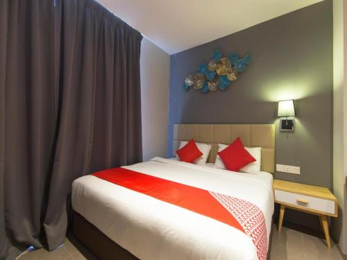 a bedroom with a large bed with red pillows at Yootel Boutique Hotel in Kajang