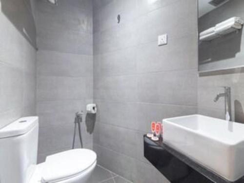 a bathroom with a white toilet and a sink at Yootel Boutique Hotel in Kajang
