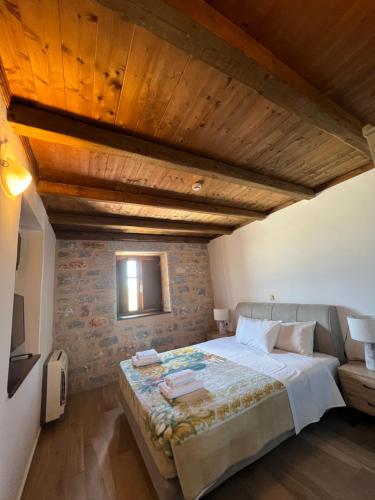 a bedroom with a large bed with a wooden ceiling at Koukouri Suites in Areopolis