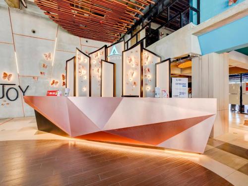 a large white counter in a room with a wall at Collection O 30 Amega Crown Sub in Surabaya