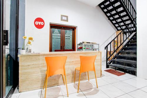two orange chairs sitting at a counter in a store at Collection O Jalan Slamet Riyadi Near Kampung Batik Kauman Formerly Hotel Grand Kota in Solo