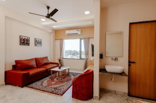a living room with a red couch and a table at Daksh The Grand Goverdhan in Dwarka