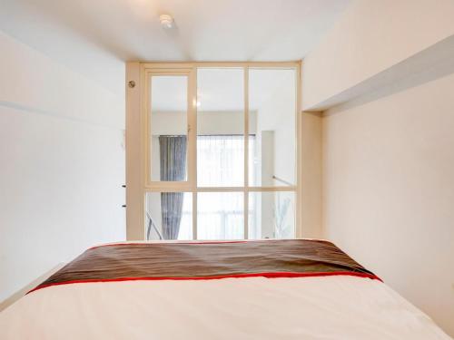 a bedroom with a bed and a window at Collection O 30 Amega Crown Sub in Surabaya