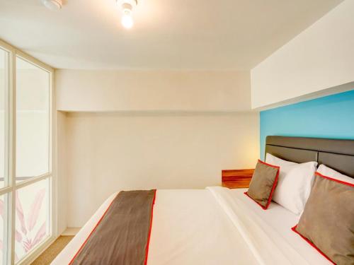 a bedroom with a bed and a large window at Collection O 30 Amega Crown Sub in Surabaya