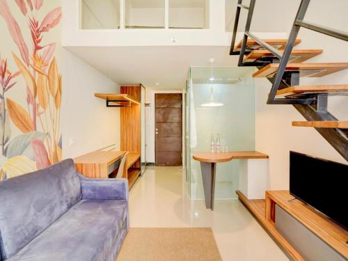 a living room with a purple couch and a tv at Collection O 30 Amega Crown Sub in Surabaya