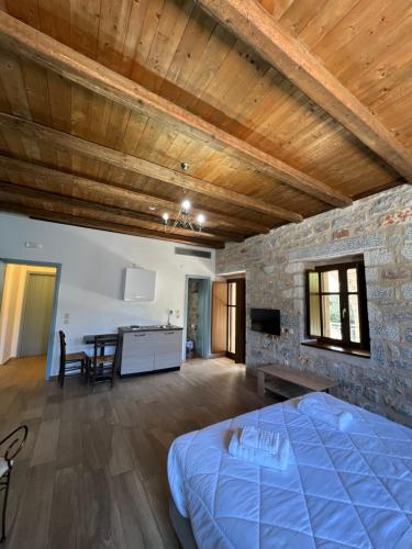 a bedroom with a bed and a stone wall at Koukouri Suites in Areopolis