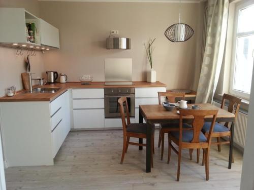 eine Küche mit Holztisch und ein Esszimmer in der Unterkunft Haus MeerZeit in Cuxhaven