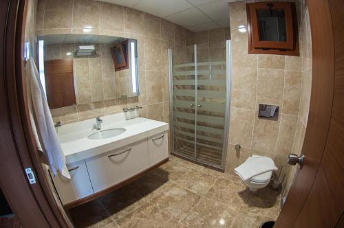 a bathroom with a sink and a shower and a toilet at Alptekin Otel in Ürkmez