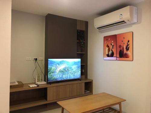 a living room with a flat screen tv on a wall at BEACH Condo Mae Phim in Ban Tha Fat