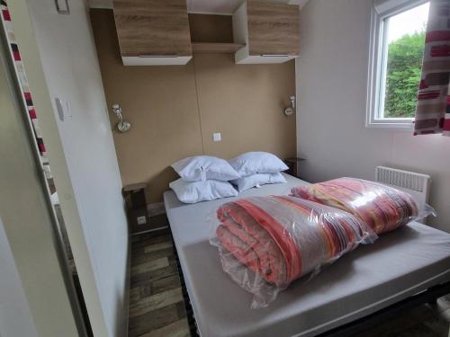 a small room with a bed with a comforter on it at Mer et Soleil 5 étoiles à Oléron emplacement 089 3CH 1SDB 8 personnes in Saint-Georges-dʼOléron