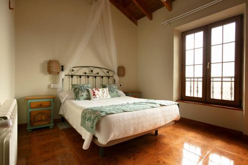 a bedroom with a bed and a large window at Posada La Herradura in Liermo