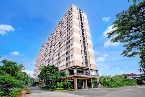 a tall white building with trees in front of it at Collection O Baros Near Stasiun Cimahi in Cimahi