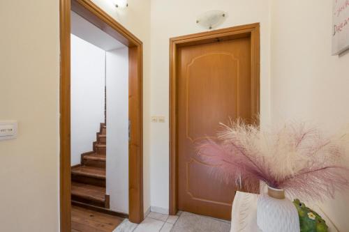 Un pasillo con una puerta y un jarrón con plumas. en Lion's Yard, en La Canea
