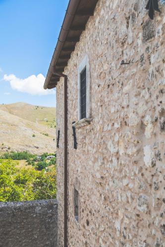 a stone building with a window on the side of it at Festina Lente - Guest House in Santo Stefano di Sessanio