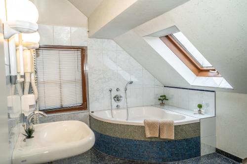 a bathroom with a bath tub and a sink at Ruby restoran & prenoćište in Nova Gradiška