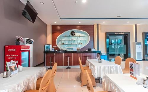 a restaurant with two tables and chairs and a counter at Collection O Hotel Igloo in Bekasi