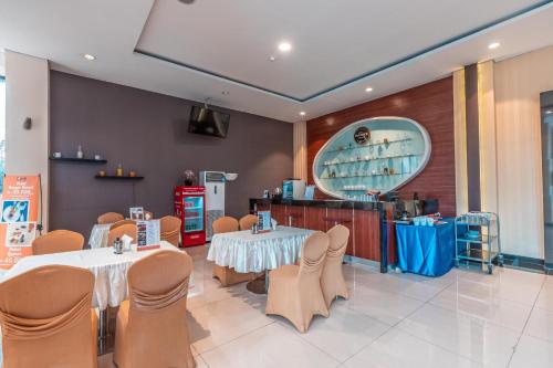 a restaurant with two tables and chairs and a counter at Collection O Hotel Igloo in Bekasi