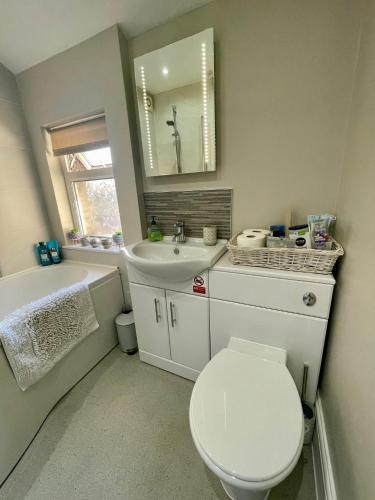 a bathroom with a toilet and a sink and a mirror at 2025 Traveller award winner Just bring clothes in West Kirby