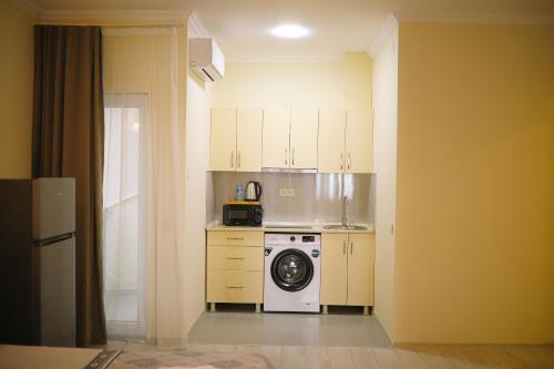 a small kitchen with a washing machine in it at Cozy Apartment Near The Beach in Kakhaberi